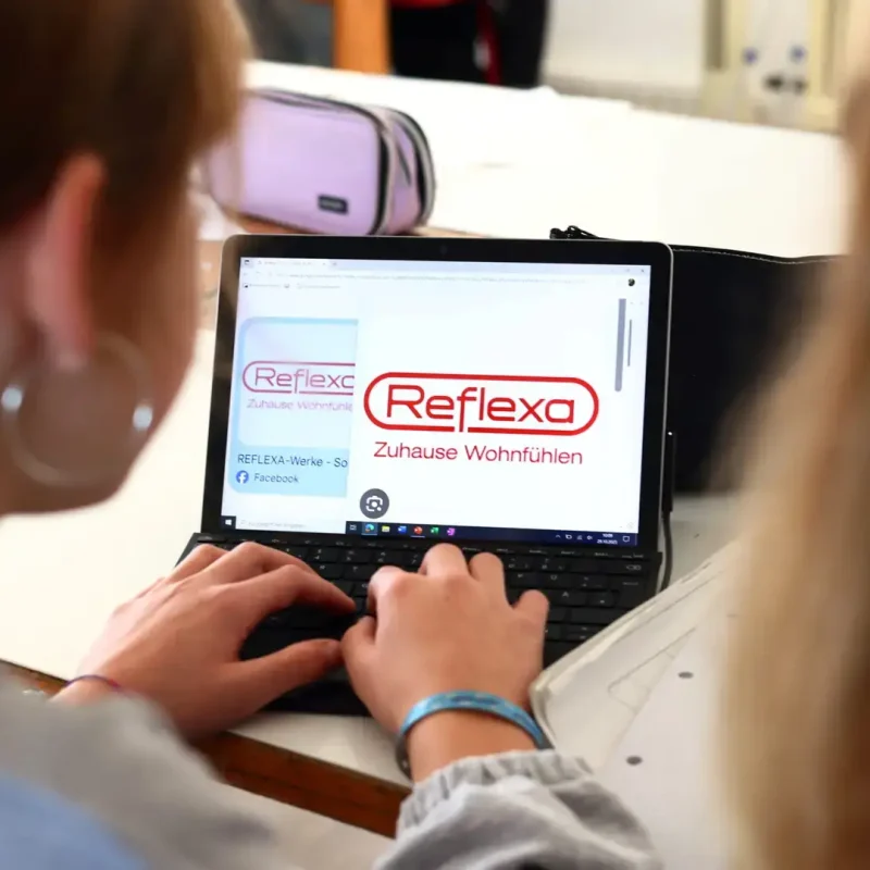 Schüler tippen an einem Tablet im Technikunterricht und recherchieren Informationen.